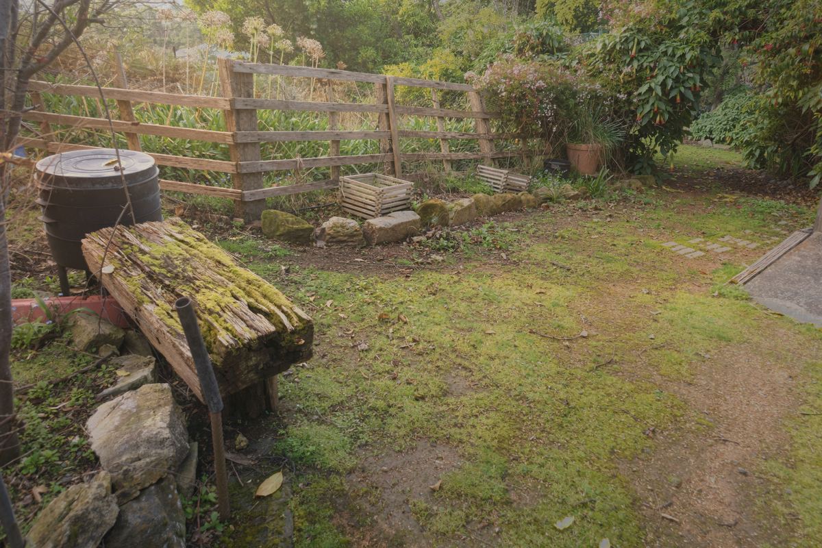A log seat by the garden beds